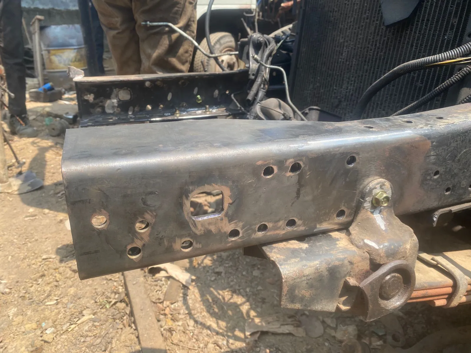 Damaged chassis rail with holes — before repair